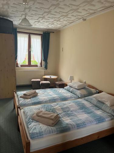 two beds in a room with two chairs and a room with two windows at Handó Porta in Szenna