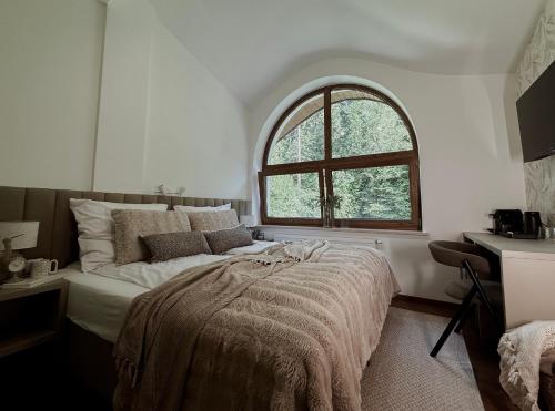 a bedroom with a bed with a large window at Zacisze pod Tatrami in Suche