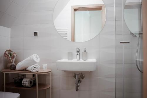 a white bathroom with a sink and a mirror at Zacisze pod Tatrami in Suche