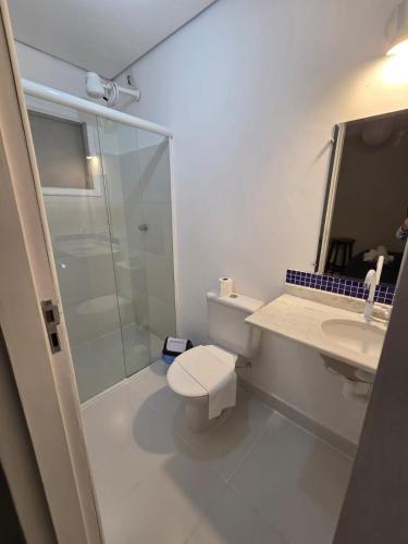 a bathroom with a shower and a toilet and a sink at Pousada Casa Meraki in São Sebastião