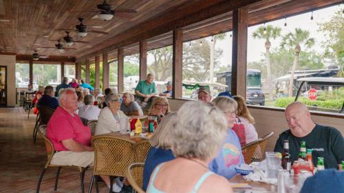 a group of people sitting at tables in a restaurant at Road Runner Travel Resort in Fort Pierce