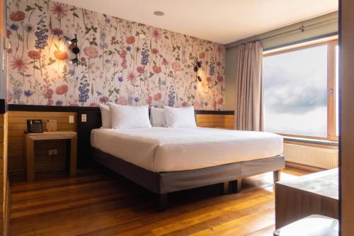 a bedroom with a bed with a floral wallpaper at Hotel Bellavista in Puerto Varas