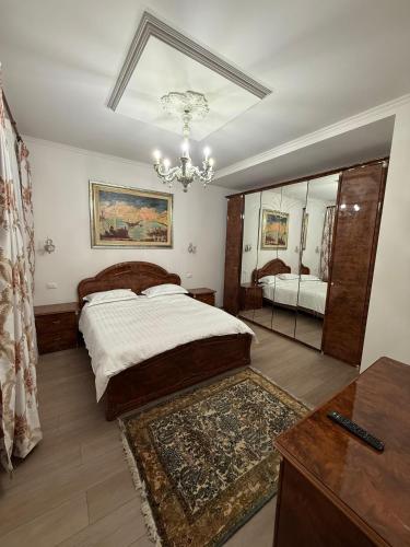a bedroom with a large bed and a chandelier at Casa Marza in Făgăraş