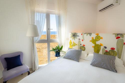 a bedroom with a white bed and a blue chair at Torre dei Pirati in Letojanni