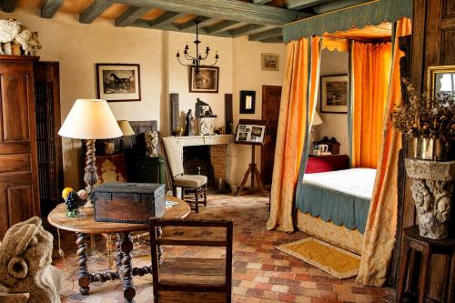 a bedroom with a bed and a table and a fireplace at Château De Chambiers in Durtal