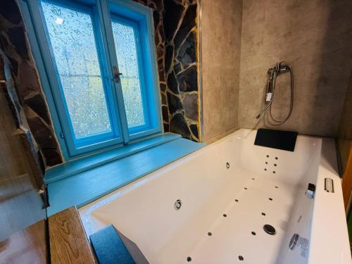 a bath tub in a bathroom with a window at Zázrak Wellness in Banská Štiavnica