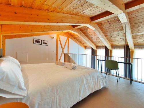 a bedroom with a large white bed in a room with wooden ceilings at Apartamentos Mantería Lacort, Valladolid in Valladolid