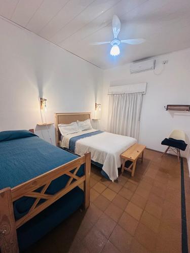 a bedroom with two beds and a ceiling fan at BichoNegro Hostel in Concordia