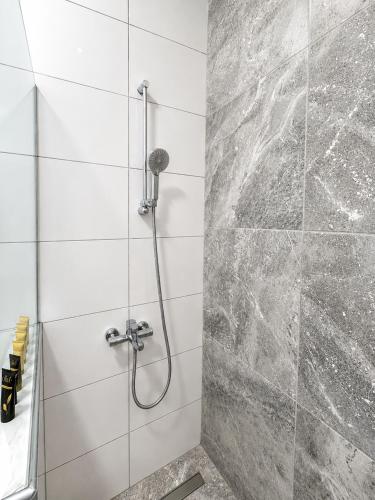 a shower in a bathroom with a stone wall at Luxury & Modern Apartment in Paralia Katerinis