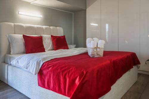 a bed with red and white pillows and a red blanket at Vake Dream Duplex in Tbilisi City