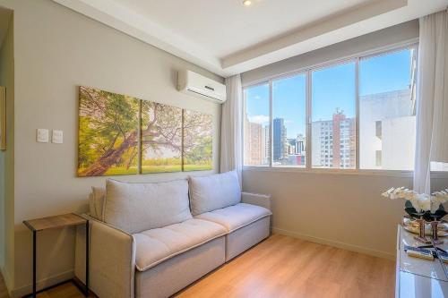 a living room with a couch and large windows at Charming apartment in downtown Floripa EDC402 in Florianópolis