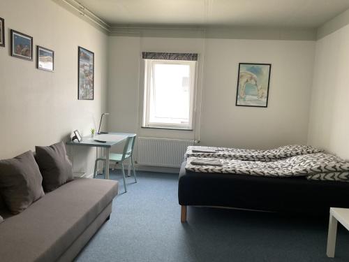 a living room with a couch and a bed and a table at Hotel Arctic Circle in Kangerlussuaq
