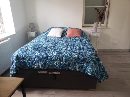 a bedroom with a bed with a blue comforter at Cocon lumineux Euratech-CHU in Lille