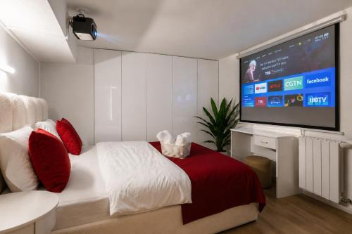 a bedroom with a bed and a flat screen tv at Vake Dream Duplex in Tbilisi City