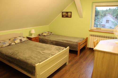 a bedroom with two beds and a window at Bocianówka 5 in Wężówka