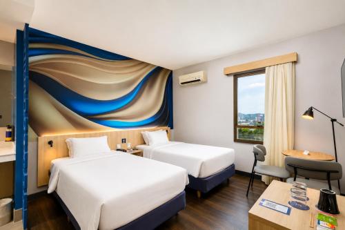 a hotel room with two beds and a mural at Comfort Hotel Joinville in Joinville