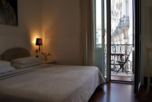 a bedroom with a bed and a view of a balcony at B&B Palazzo Sant'Alfano in Catania