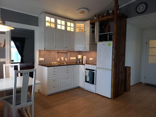 a kitchen with white cabinets and a white refrigerator at Rólegt in Ísafjörður