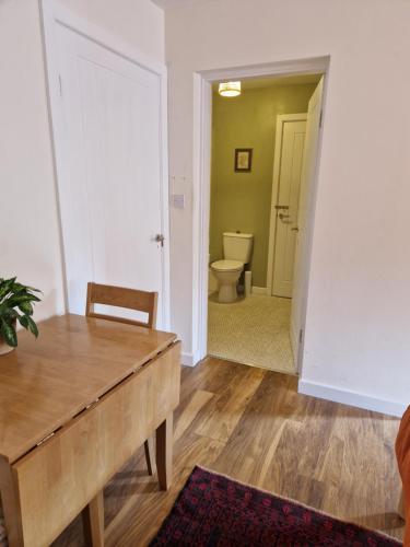 a living room with a table and a toilet at Fairways in Melrose