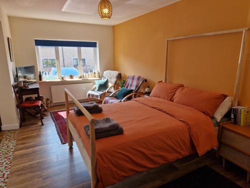 a bedroom with a bed with an orange bedspread at Fairways in Melrose