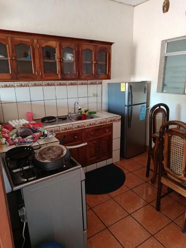a kitchen with a stove and a refrigerator at Hostal Expansion in San Juan del Sur