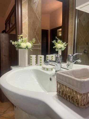 a bathroom with a sink and a tub with flowers on it at Nenniri's house in Villamassargia