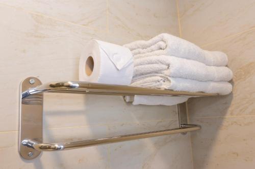 a towel rack with towels and a roll of toilet paper at Hotel Qamiri in Arica