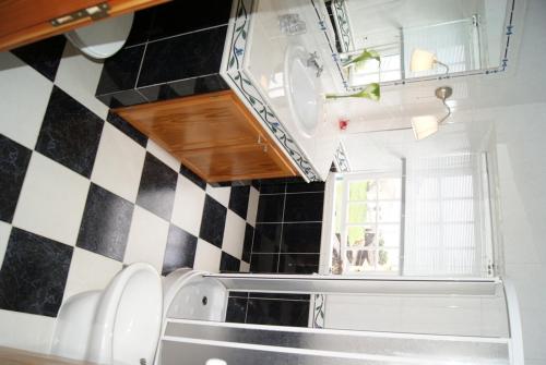 a kitchen with a black and white checkered wall at Casa do Comendador in São Roque do Pico