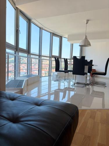 a living room with a couch and a table and chairs at Matey Luxury Sky Apartment in Bitola