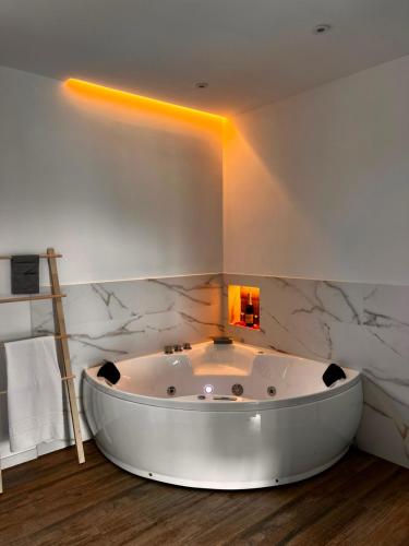 a white bath tub in a bathroom with marble walls at La Muraza in Villaviciosa