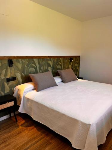 a large bed with two pillows on it in a bedroom at La Muraza in Villaviciosa
