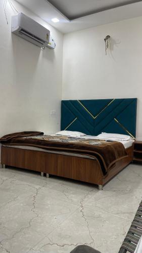 a large wooden bed in a room with a wall at Hotel 48 in Amritsar