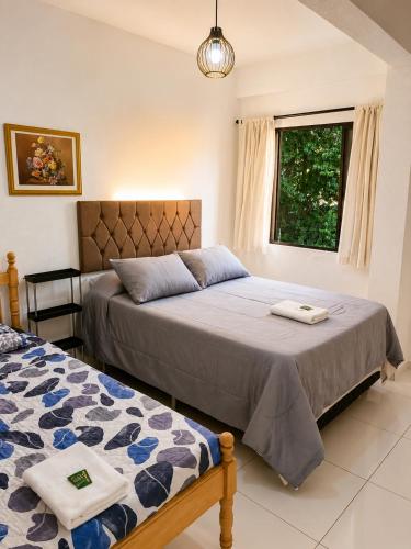 a bedroom with two beds and a window at LEON MARIA HOSPEDAGENS - Smart Flat Hotel e Residence in Mogi das Cruzes
