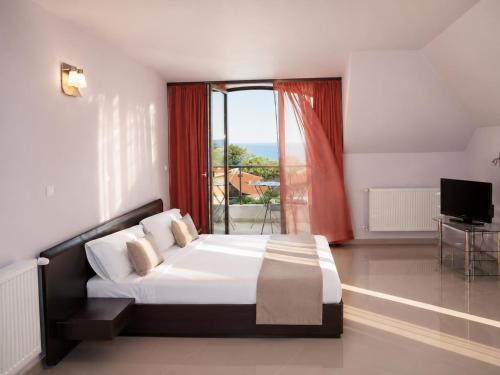 a bedroom with a bed and a large window at Silistar Hotel in Rezovo