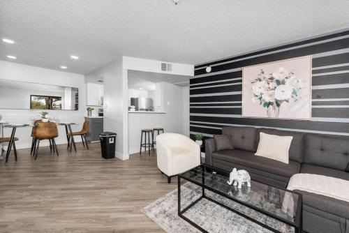 a living room with a couch and a dining room at Chill 2BR Near ASU, Pool, Grill, Parking,Pet Frndly in Tempe