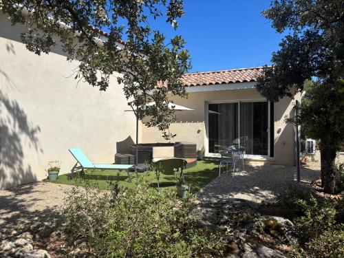 a backyard with a patio furniture and a house at Au Petit Bueix in Sillans-la Cascade