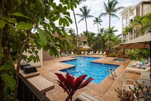 a swimming pool in a resort with palm trees at Grand Champions 185 in Wailea