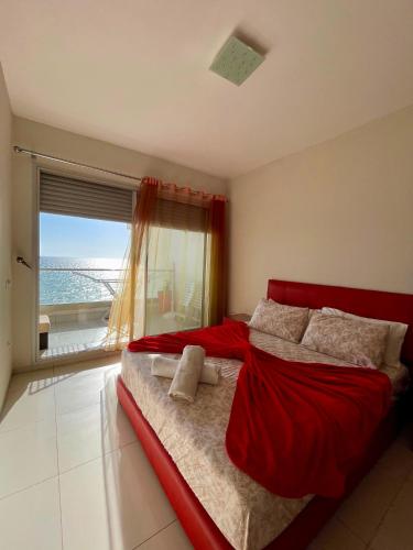 a bedroom with a red bed with a view of the ocean at Atlas Ocean View Vue Mer Directe in Aourir
