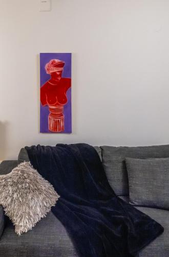 a blanket on a couch with a painting on the wall at 4 Travelers in Thessaloniki