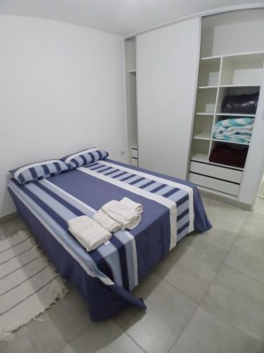 a bedroom with a blue and white bed with folded towels at Departamento ÚNICO in Presidencia Roque Sáenz Peña