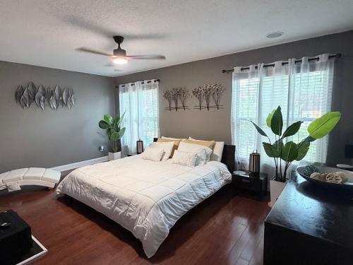 ein Schlafzimmer mit einem großen Bett mit weißer Bettwäsche und Fenstern in der Unterkunft Davis Isle Private Resort Luxury in Orlando