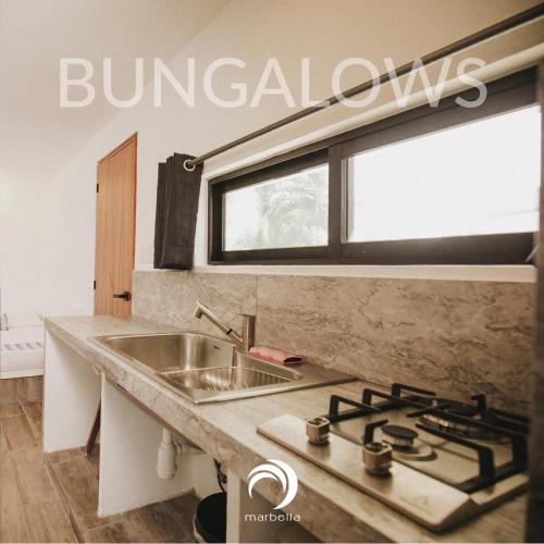 a kitchen with a sink and a stove at Hotel Bungalows Marbella Costa Esmeralda in Monte Gordo