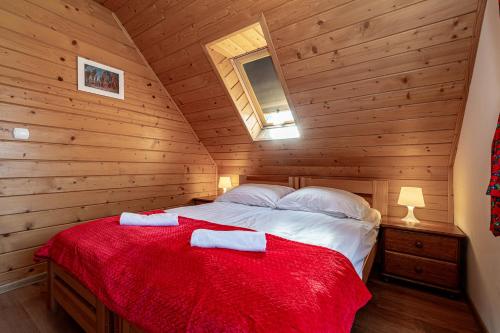 a bedroom with a bed in a wooden cabin at DW KINGA Domki całoroczne 6 os z widokiem na Tatry in Kacwin