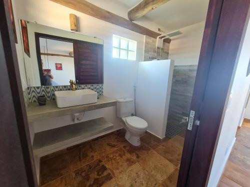 a bathroom with a toilet and a sink and a mirror at Casa Bea in Fortim