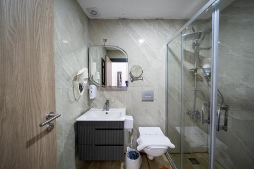 a bathroom with a shower and a sink and a toilet at Akyalı Boutique Hotel in Guvercinlik
