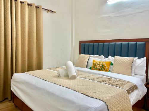 a bedroom with a large bed with a blue headboard at Land Chaster Kasauli in Kasauli