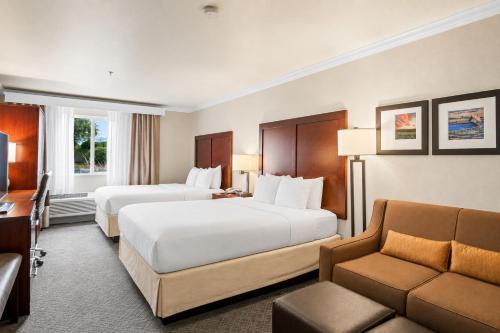 a hotel room with two beds and a couch at Comfort Inn Columbia Gorge in The Dalles