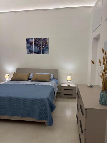 a bedroom with a blue bed and two night stands at Sorrento Gem House in Meta