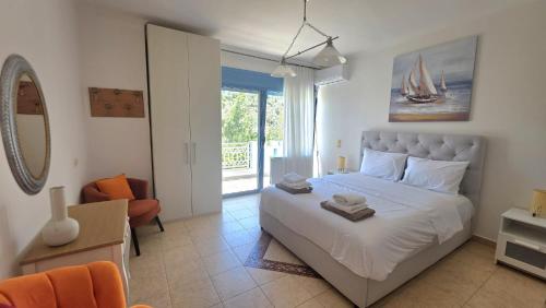 a bedroom with a white bed and a balcony at Villa Garden and Sea Lefkada in Lygia
