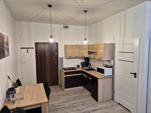 a kitchen with white walls and wooden cabinets at Noclegi Piastów 25 in Nowa Ruda